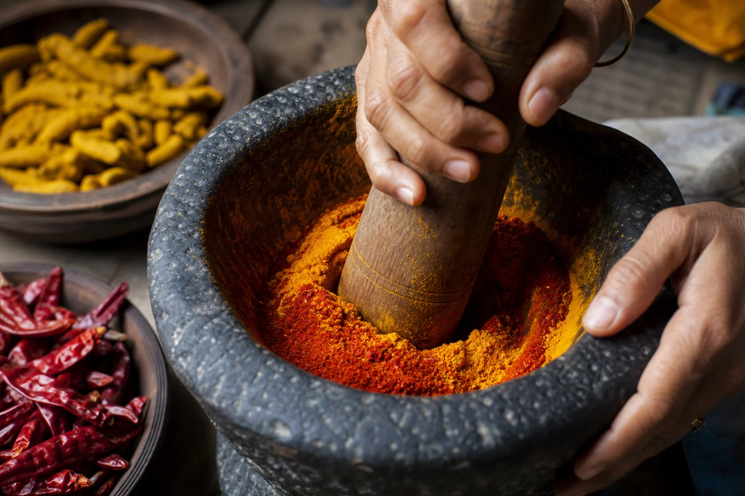 Traditional stone okhli grinding spices by hand